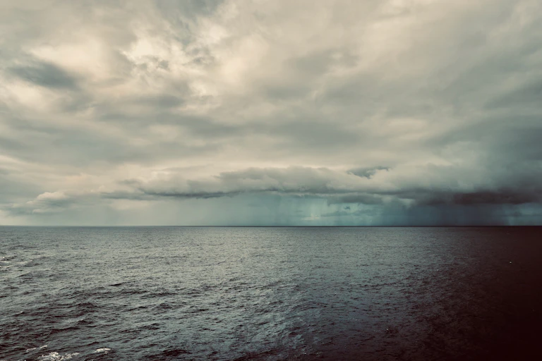 storm clouds hover over ocean