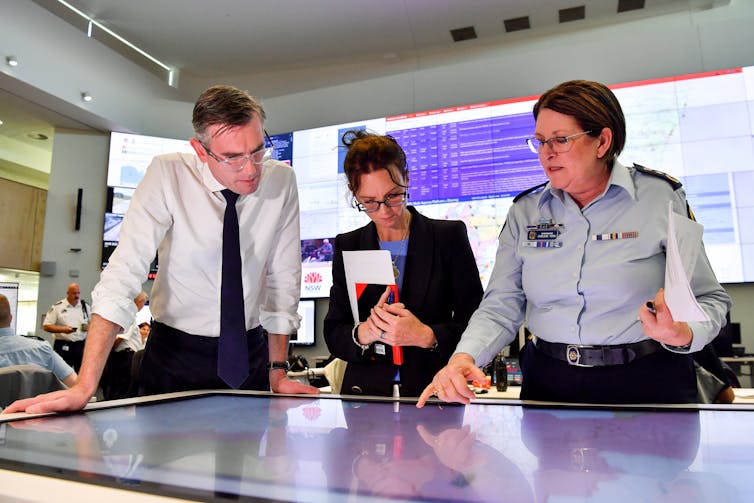 a man and two women look at map