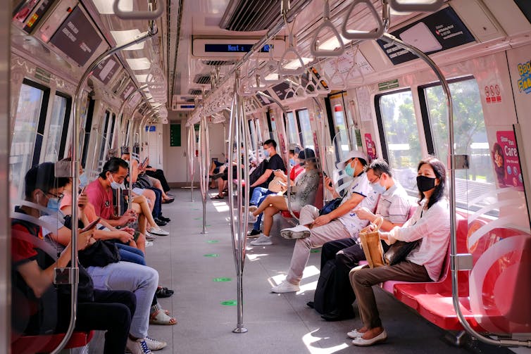 In einem Zug in Singapur tragen Menschen Gesichtsmasken