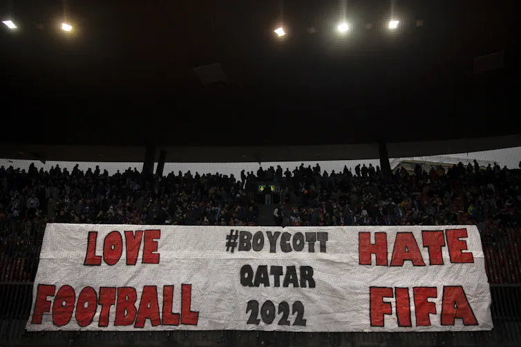 Fans of FC Zurich holding a sign saying 'love football, hate FIFA, boycott Qatar 2022'