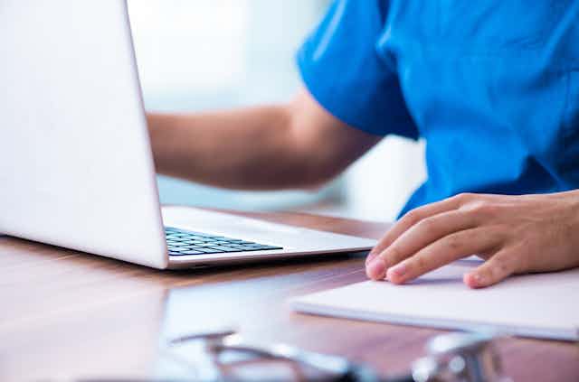 medical person sitting at laptop