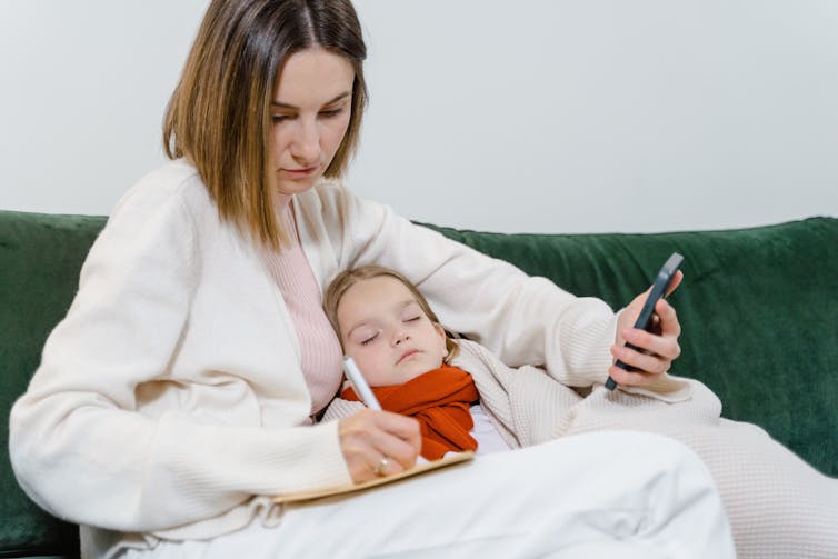 woman comfort child while on phone