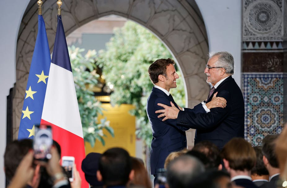 Le président Emmanuel Macron salue le recteur de la Grande Mosquée de Paris Chems-eddine Hafiz lors de la remise de la Légion d'honneur en marge de l'inauguration d'une exposition célébrant cette institution, le 19 octobre 2022.