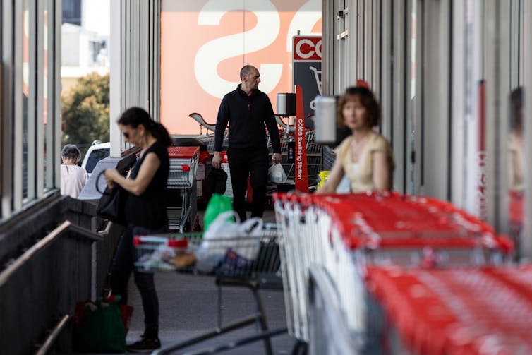 Shoppers with trolleys outside Coles