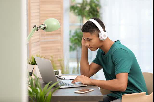 A teenage boy on a laptop.