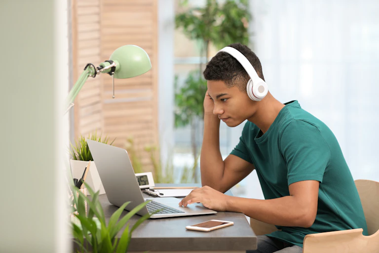 A teenage boy on a laptop.