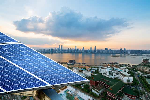 A solar panel with a city skyline in the background.