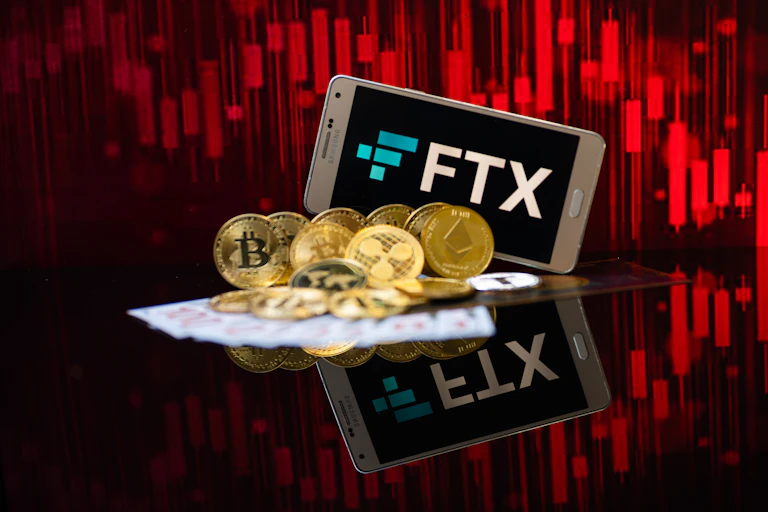 A phone with FTX on it against a red background.