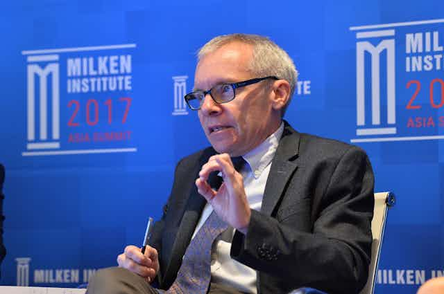 Man in suit and glasses giving a speech