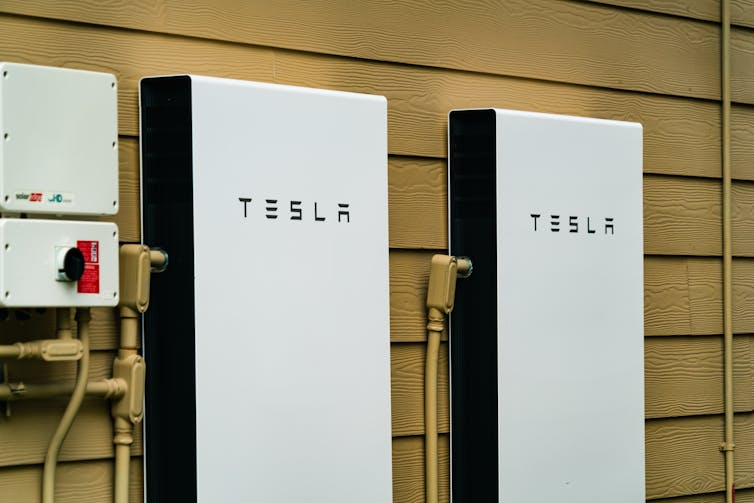 Two Tesla Powerwalls, the company's household energy storage system, mounted on a wall.