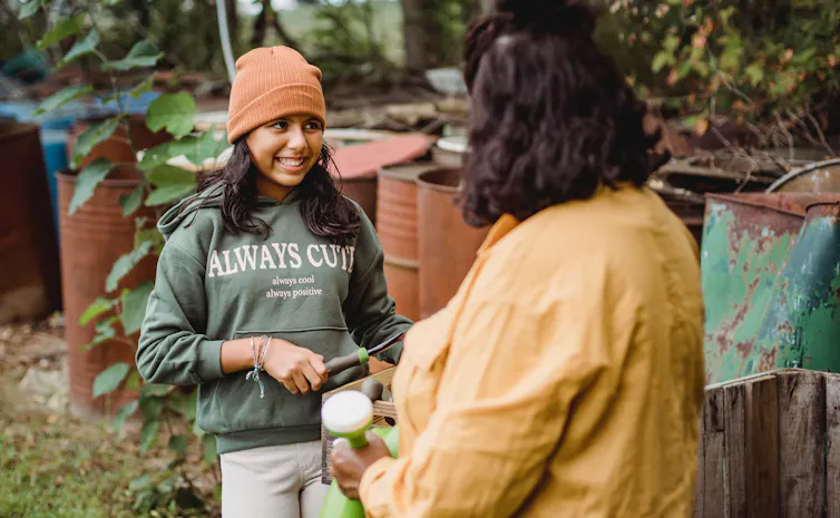 A girl in a sweatshirt that says 'always cute, always cool, always positive.