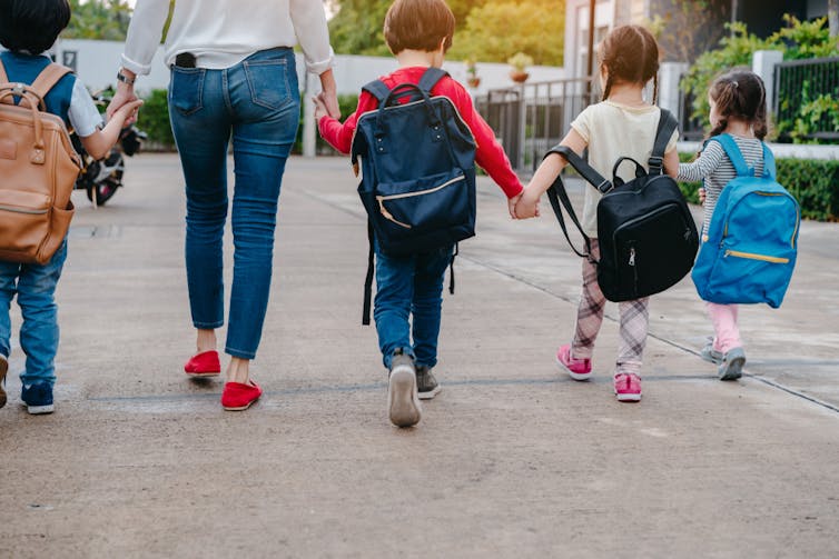 Children walking to school wearing backpacks.