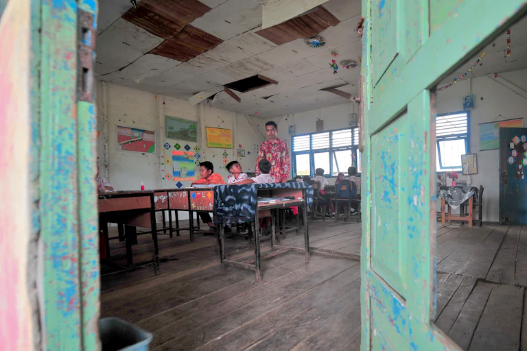 Seorang guru memberikan materi palajaran kepada siswa kelas 5 dan 6 SDN 71 Sungai Sayang di Jambi.
