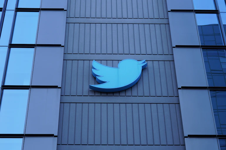 The Twitter logo, a blue bird, adorns the outside of their glass San Francisco building