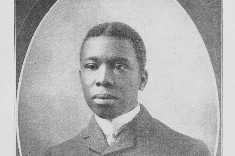 An oval-shaped portrait of black man wearing white shirt and dark jacket.