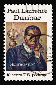 A postage stamp bearing the image of a black man resting his chin on his hand.
