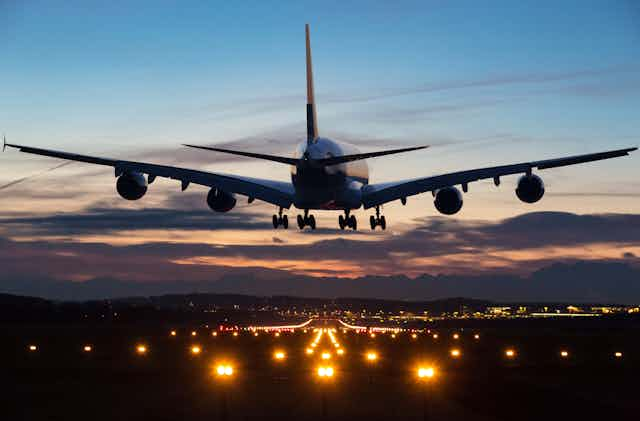 large airplane descends toward a runway