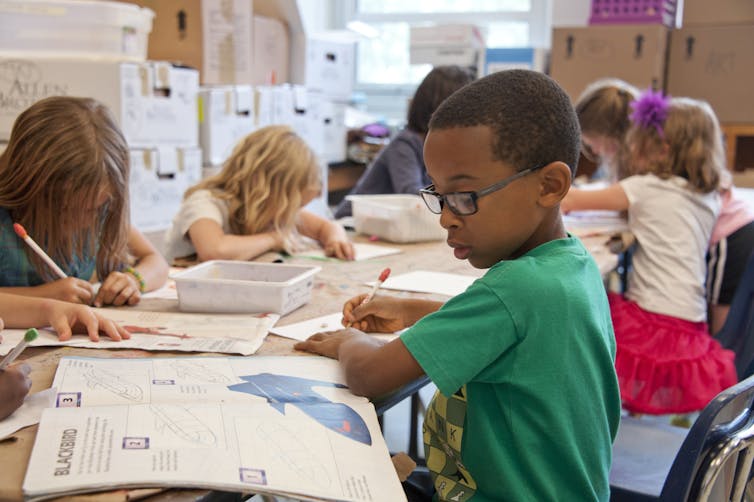 Primary students working on different activities at a group table.