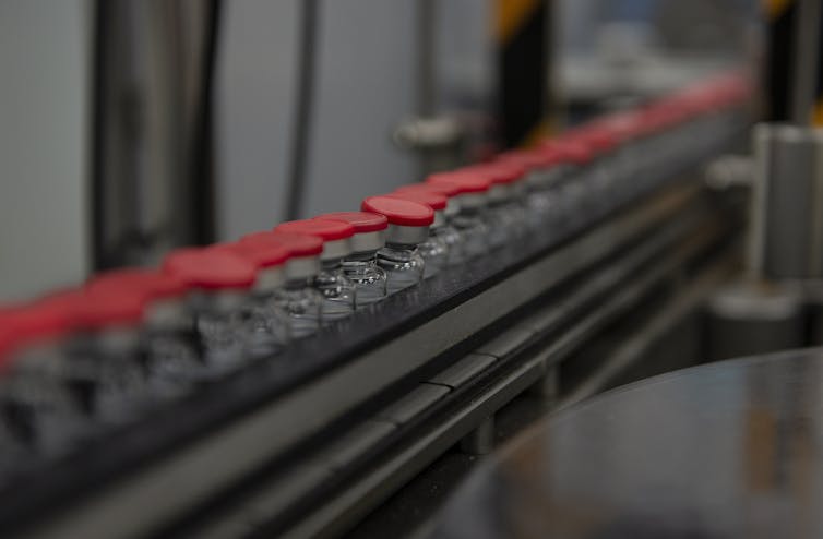 vaccine vials on conveyor belt