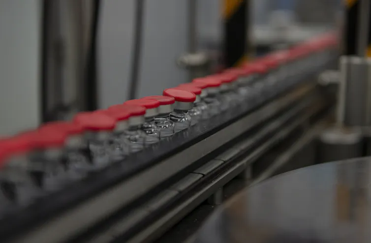 vaccine vials on conveyor belt