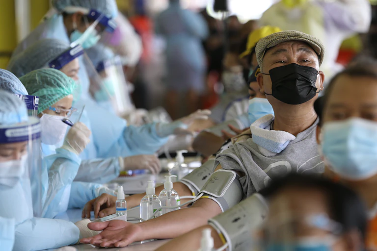 Thai people sitting for COVID vax