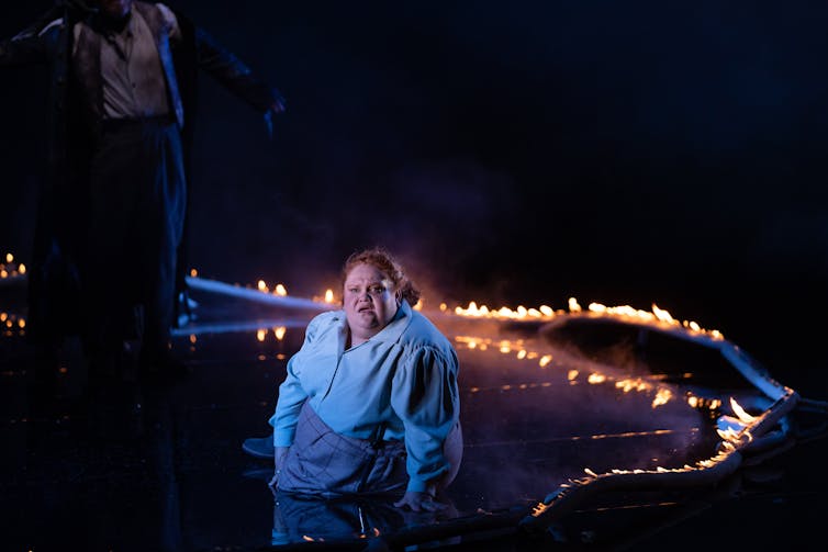 A woman sits on stage