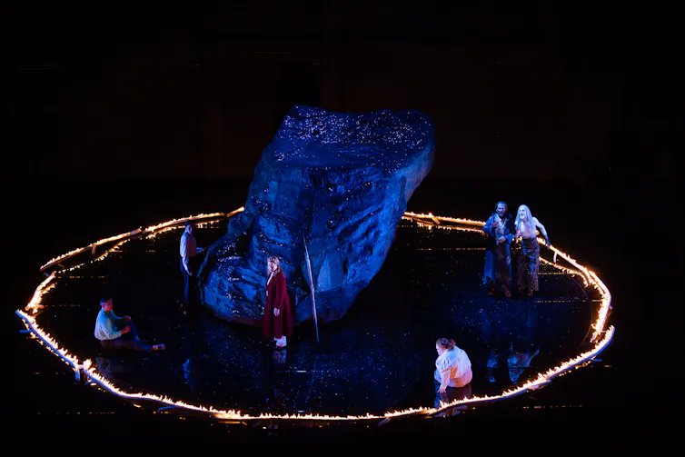 Actors on stage, a ring of fire.