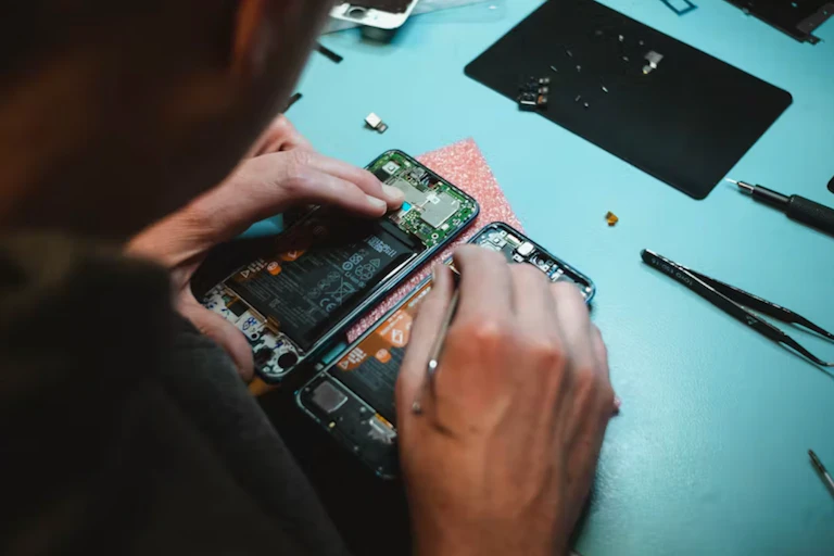 main d'un homme qui répare un smartphone