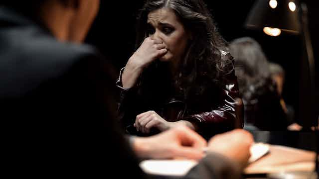 a tearful woman sits across from a man