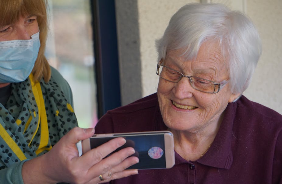 Personne âgée à qui l'on montre un smartphone
