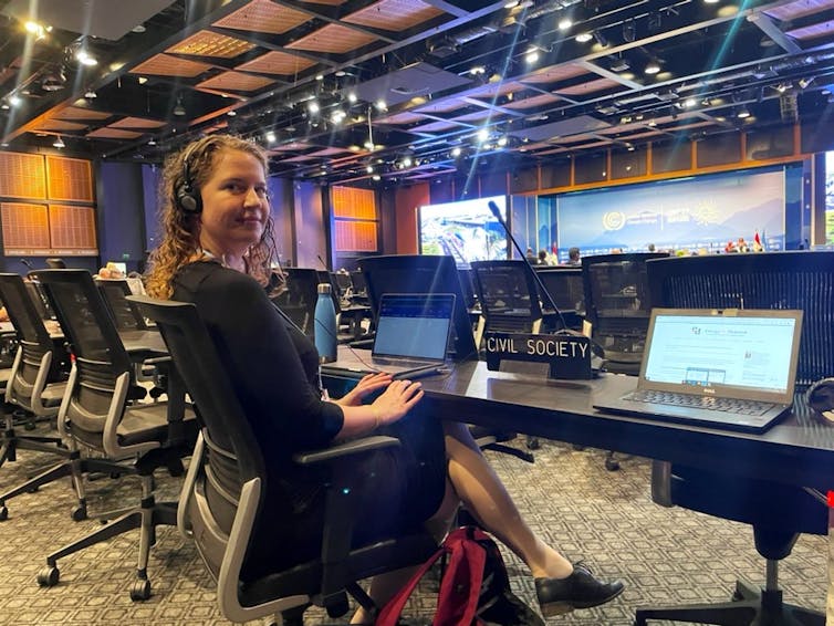 Woman sits in large conference room