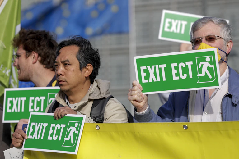 3 protestors holding green signs reading "Exit ECT".
