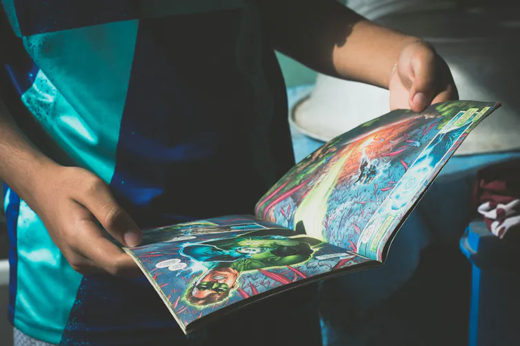 A kid flicks through a comic