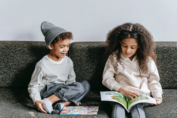 Two children look at a picture book