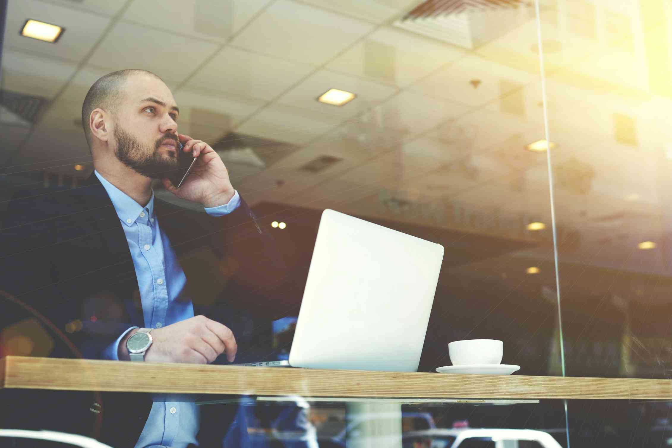Concerned man on the phone in a cafe.