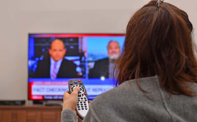 Person watching the news on TV