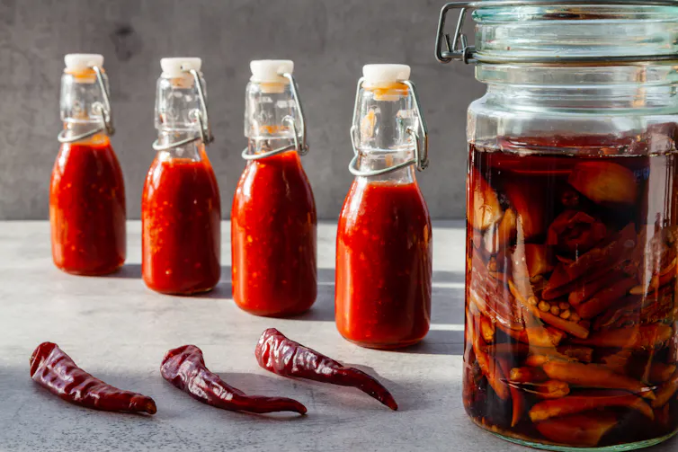 chillis in jars, on table, in sauce