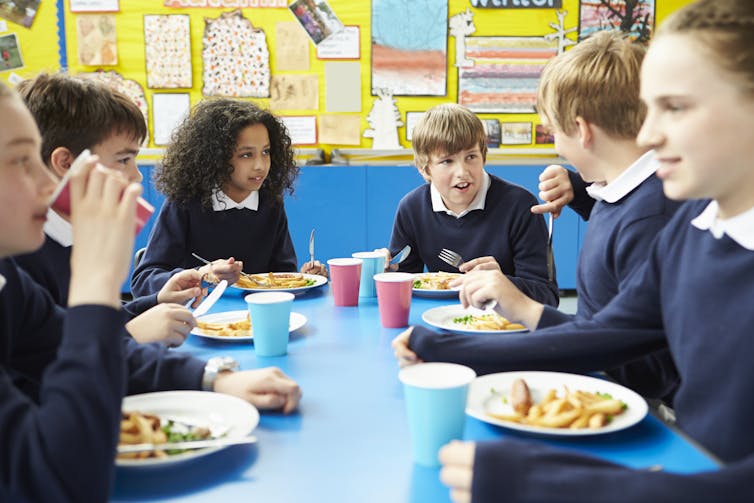 Children in uniform eating lunch