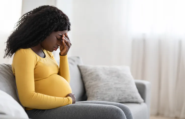 Pregnant woman looking despondent.