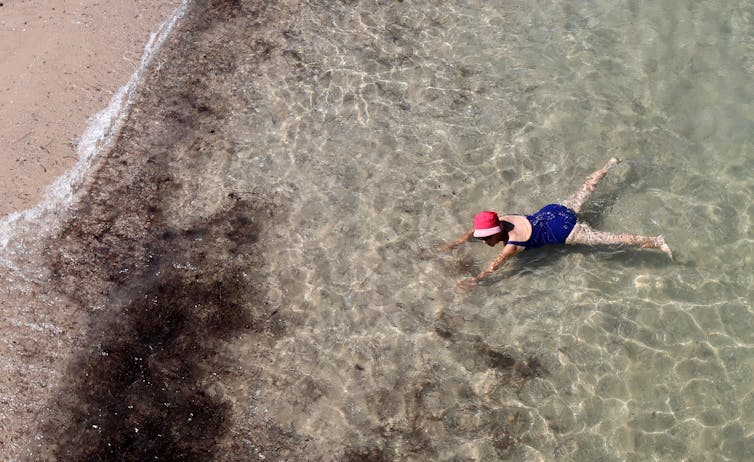 woman floats in water at beach
