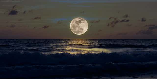Luna llena sobre mar oscuro.