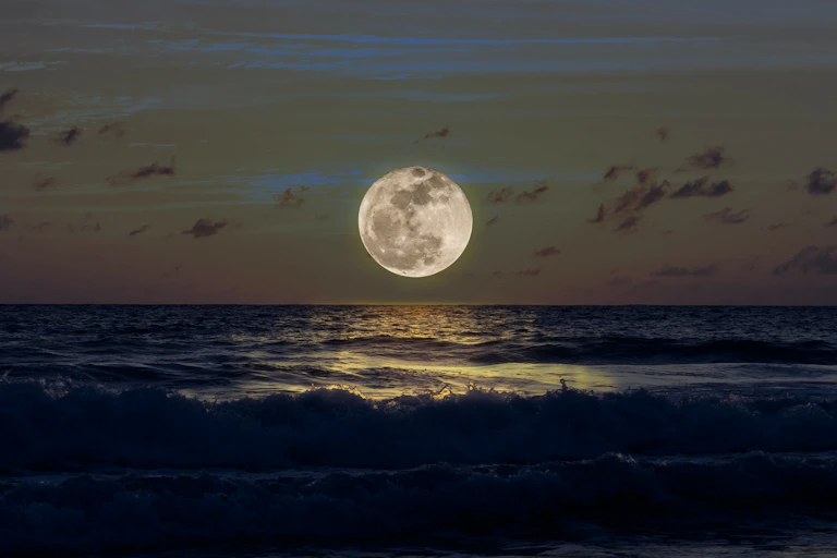 Luna llena sobre mar oscuro.
