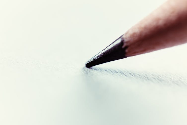 A close-up photo of the tip of a pencil writing on paper.