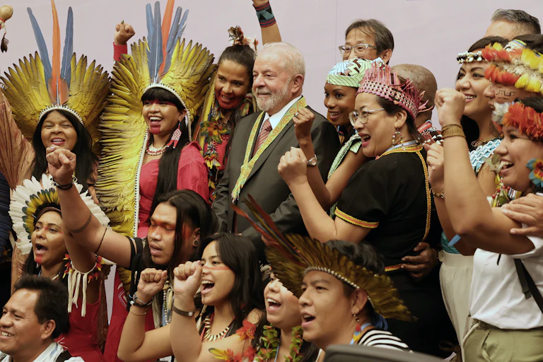 Lula en compagnie de militants indigènes brésiliens en costume traditionnel