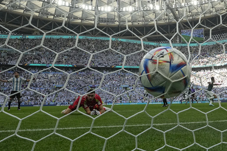 A soccer ball hits the net in a goal.