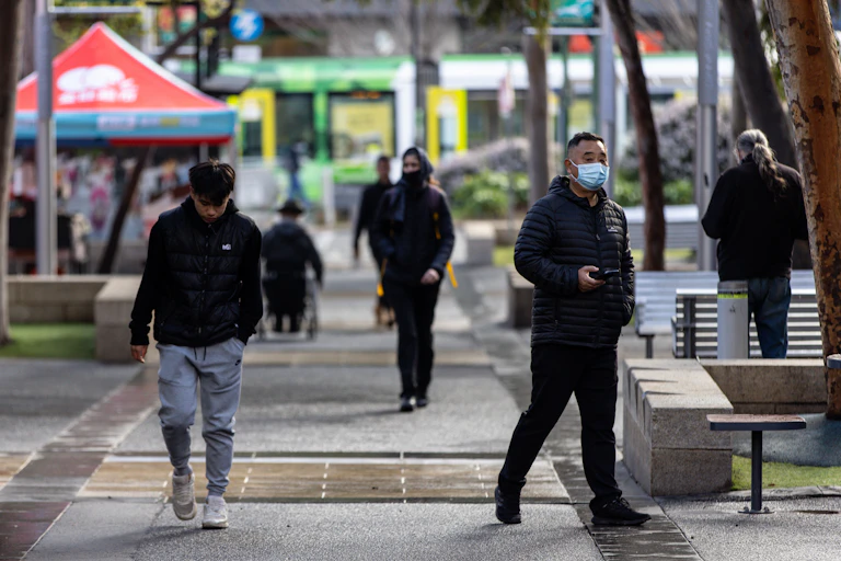People walking in Melbourne with tram in background