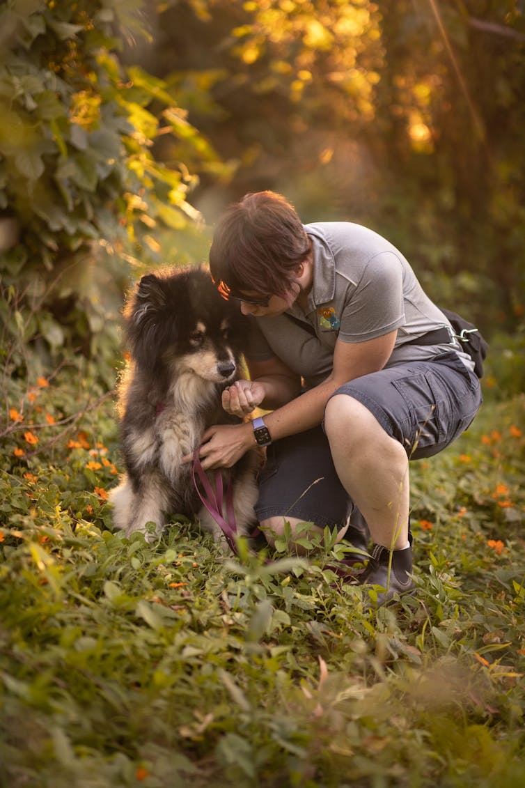 A person cuddles a dog