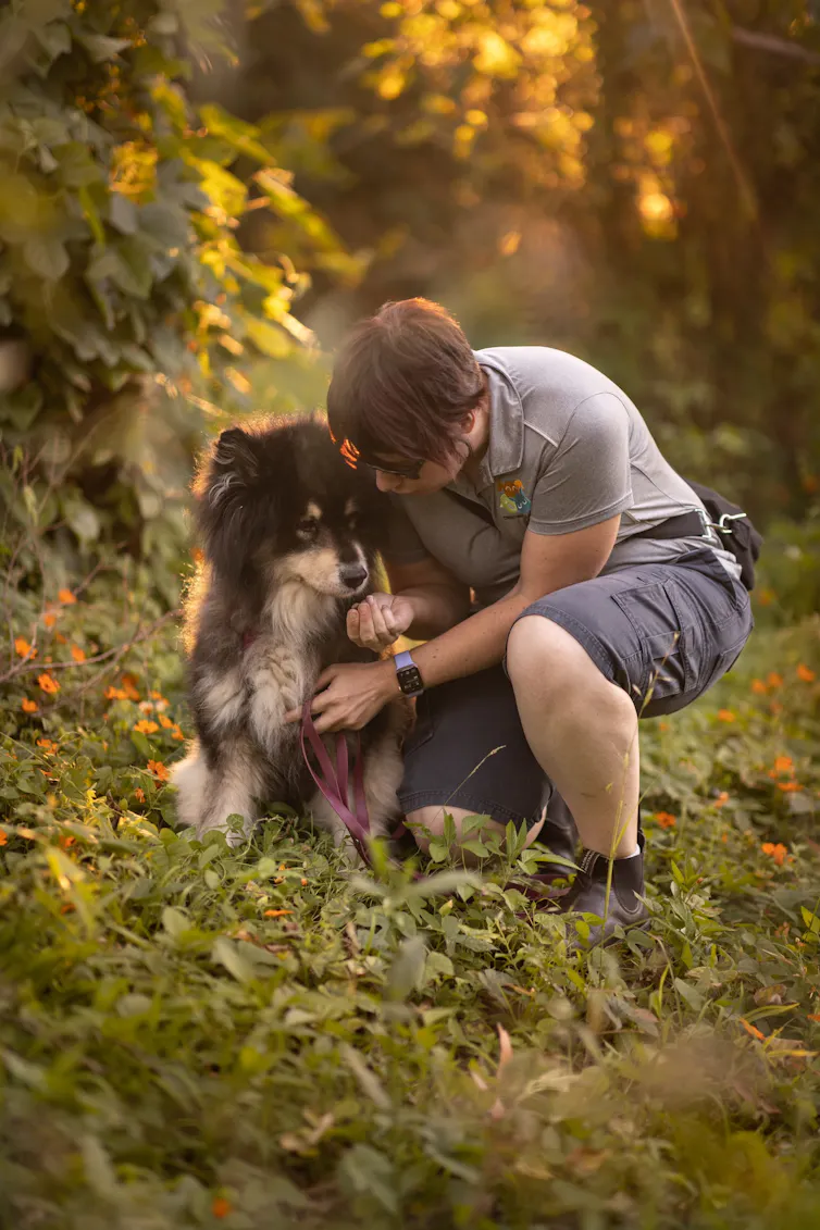A person cuddles a dog