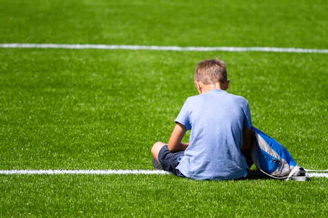 A boy looks sad at a sport match