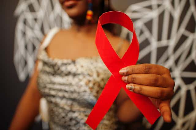 black woman holds red ribbon